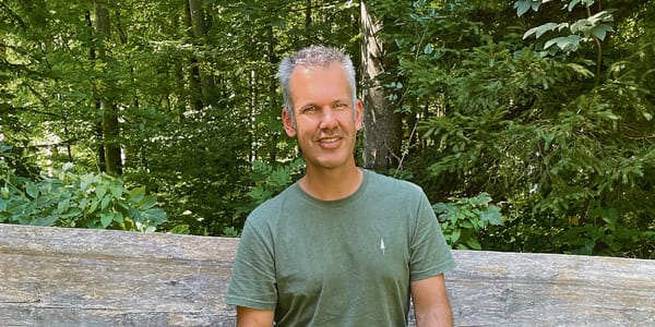 Hat er selbst gebaut: Manuel Peterhans auf einer Bank vor dem Forsthaus. Sein Leitsatz, der auch über dem Eingang zum Forstha